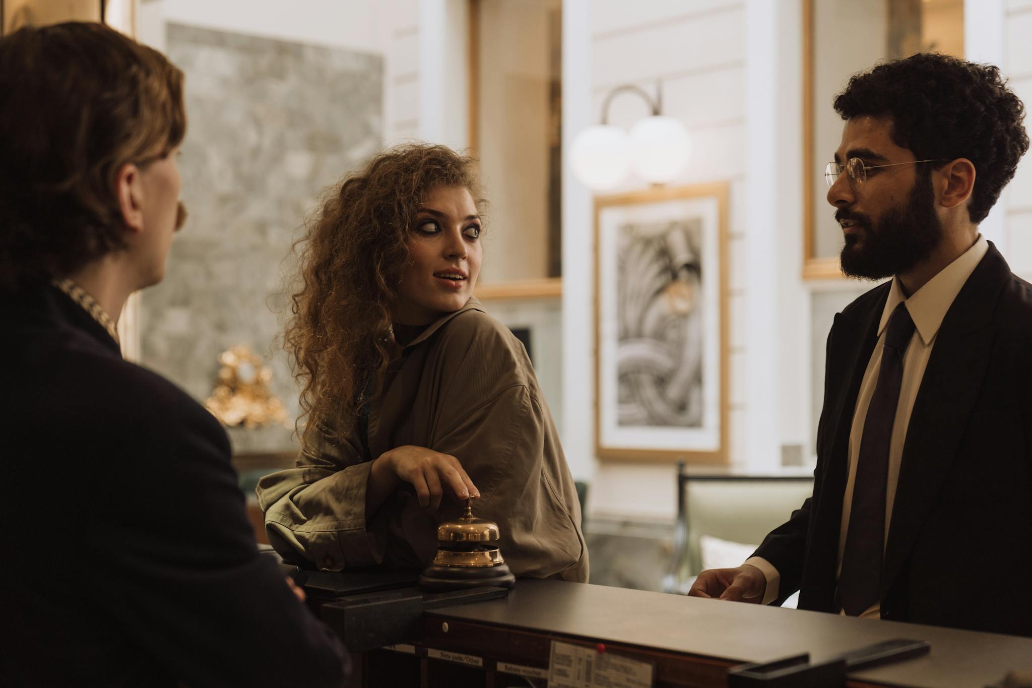 Guests interacting at a luxurious hotel reception desk, emphasizing hospitality and service.